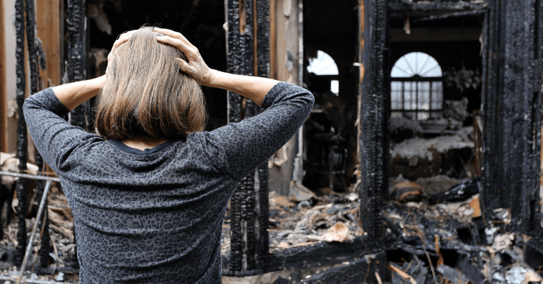 Woman looking at burned home