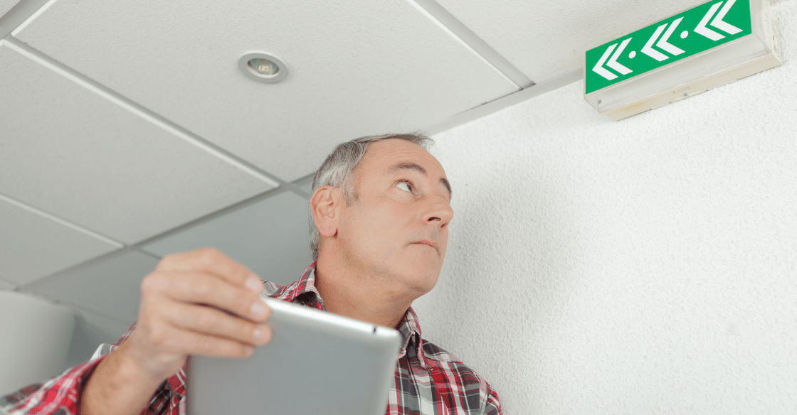 Man inspecting an emergency light